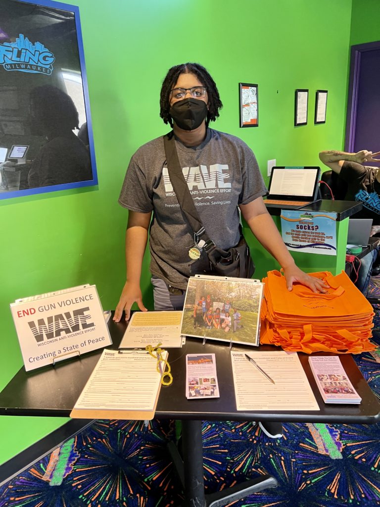 A person behind a table covered in gun violence prevention information.